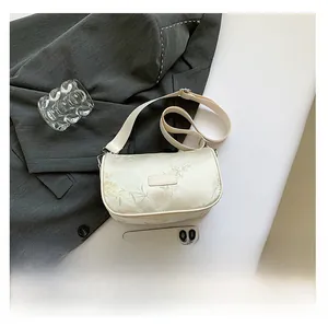 Detailed overhead shot of cream satin embroidery bag on a suit with modern accessories