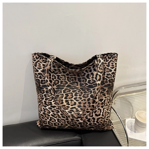 Sac fourre-tout à imprimé léopard posé sur un banc noir pour un look urbain et stylé