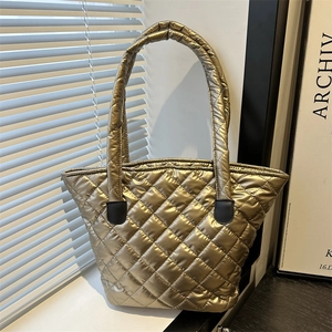 Golden quilted tote bag with metallic texture and spacious design for stylish commuting