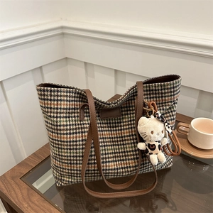 Große Karo-Canvas-Tasche mit braunen Lederriemen und plüschigem Katzenanhänger