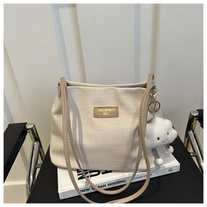 Détail du cabas gaufré crème avec bandoulière marron et pendentif nuage en peluche