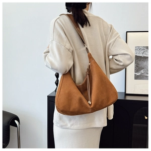 Vue détaillée du sac cabas en daim marron avec fermeture à franges et bandoulière