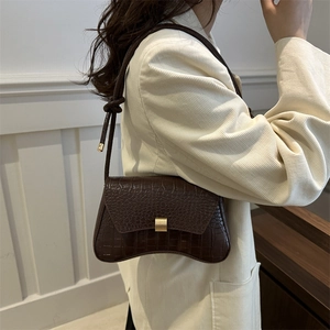 Minimalist brown crocodile pattern shoulder bag with curved base and golden buckle