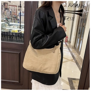 Détail du sac Hobo en daim kaki avec coutures décoratives et tirette de zip en cuir