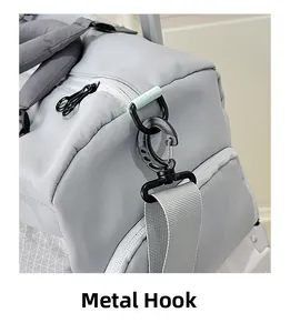 Detail of durable black metal hook and reinforced shoulder strap on grey travel bag