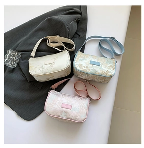 Detailed overhead view of floral embroidery handbags in beige, blue, and soft pink shades