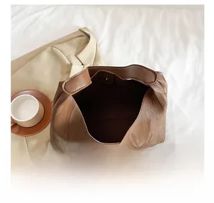 Detail view of brown textured tote bag showing magnetic closure and spacious interior