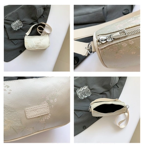 Detail of floral embroidery on beige fabric bag with metal zipper and leather tag