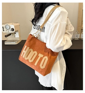 Détail du sac cabas en toile marron avec broderie HOO TO et bandoulières en cuir