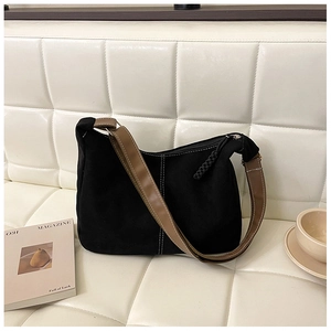 Détail du sac cabas noir minimaliste avec coutures contrastées et bandoulière en cuir brun