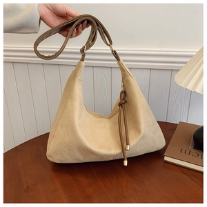 Détail du sac cabas beige givré avec bandoulière en cuir marron et décor de franges