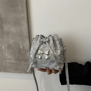 Chic silver pleated bucket bag with marble texture and metallic bow detail