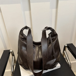 Minimalist dark brown leather tote bag with wide shoulder strap and silver buckle