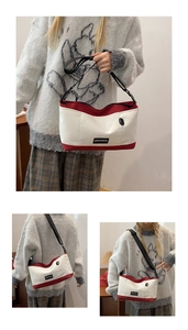Detail of red and cream contrast crossbody bag with black adjustable strap and logo