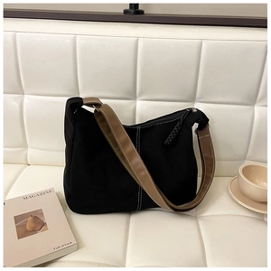 Détail du sac cabas noir minimaliste avec tissu texturé et bandoulière en cuir marron