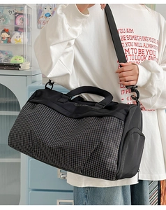 Detail of black plaid fitness travel bag showing durable fabric and adjustable shoulder strap
