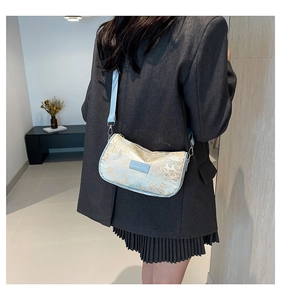 Detailed view of traditional Chinese embroidery handbag worn as a stylish crossbody bag