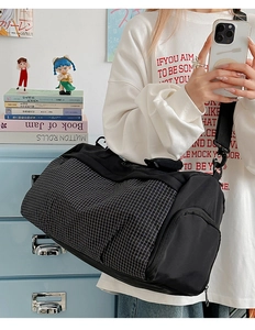 Close-up of black and white grid patterned fitness travel bag with adjustable strap