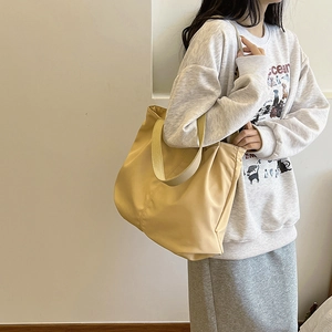 Minimalist large capacity canvas tote bag in yellow shown on model for daily commuting