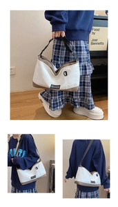 Detailed close-up and lifestyle view of a two-tone canvas crossbody bag with adjustable strap