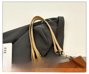 Détail du sac en velours côtelé marron avec bandoulière en cuir et anneau doré poli