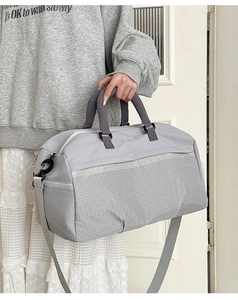Detail of grey waterproof nylon gym bag with textured pattern and detachable shoulder strap