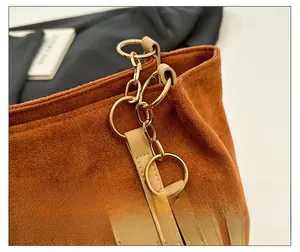 Gros plan du sac cabas en daim caramel avec anneaux dorés et patchwork de cuir fin