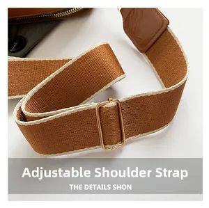 Detail of adjustable brown woven shoulder strap with gold buckle and cream piping