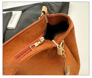 Détail de la fermeture éclair en métal doré et du tissu en velours côtelé marron du sac