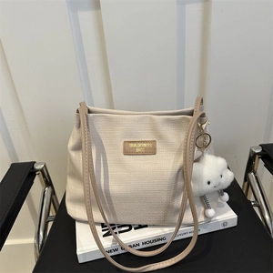 Sac cabas beige tressé minimaliste avec étiquette en cuir et peluche nuage