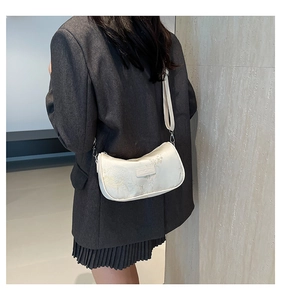 Detailed back view of a chic cream satchel featuring gold jacquard embroidery