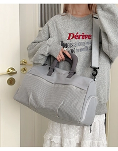 Detail of grey fitness travel bag showing side zipper pocket and comfortable shoulder strap