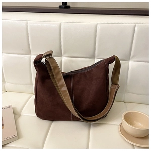 Détail du sac fourre-tout marron vintage avec surpiqûres blanches sur un canapé