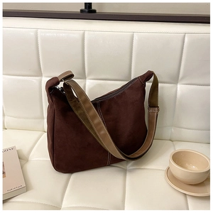 Détail du sac vintage marron montrant les coutures blanches et les boucles métalliques