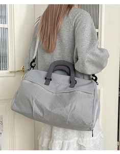 Detail view of the gray fitness bag showing the durable mesh texture and sturdy handles