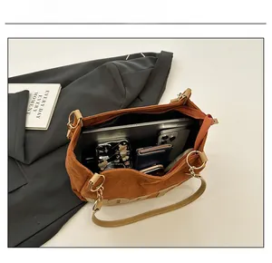 Détail du grand sac cabas en daim marron montrant sa capacité pour un ordinateur portable