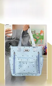 Borsa tote celeste con stampe di stelle e pois neri in un contesto quotidiano