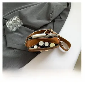Spacious interior of brown crossbody bag showing capacity for phone and cosmetics