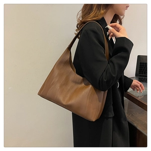 Detail of caramel leather tote bag with unique wood grain texture for professional commuters