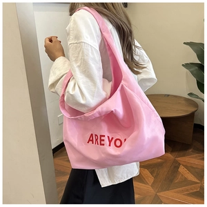 Détail du sac cabas rose avec lettres ARE YOU rouges et finition tissu brillant
