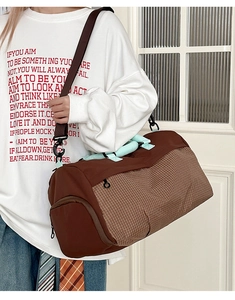 Detail view of large capacity fitness travel bag with brown checkered pattern and straps