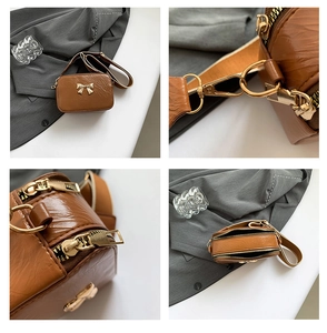 Detail of caramel leather crossbody bag with golden bow and three zipper compartments