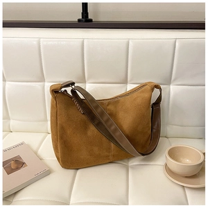 Sac hobo en daim caramel sur un canapé avec magazine et café, style décontracté