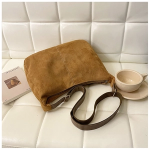 Gros plan d'un sac cabas vintage marron caramel en suède doux avec bandoulière réglable