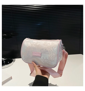 Detail of light pink cylindrical crossbody bag with traditional Chinese landscape embroidery