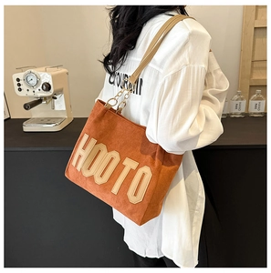 Détail du sac cabas orange en velours avec patch HOO TO et bandoulière en chaîne métal