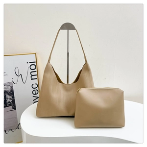Detail view of khaki tote bag set showing vertical wood grain embossed texture and inner pouch