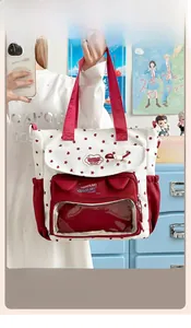 Detail of white ita bag featuring a red star print and transparent PVC display pocket