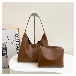 Detailed view of brown tote bag set with vertical texture and matching pouch accessories