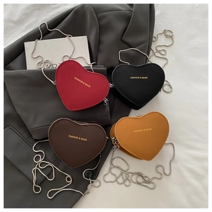 Détail de mini sacs à bandoulière en forme de cœur en rouge, noir, café et jaune